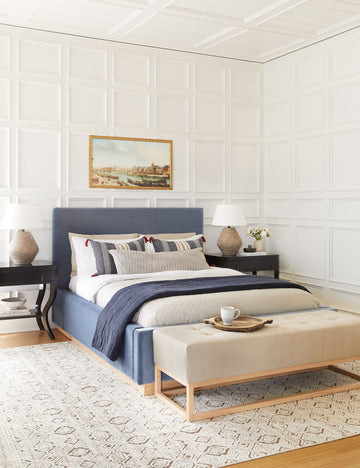 #color::natural-and-black #size::14--x-40- #insert::down #insert::polyester | The Peregrine black and white marled striped lumbar pillow lays in a modern english inspired bedroom with a navy framed bed, a sand-toned bench, and white accented walls