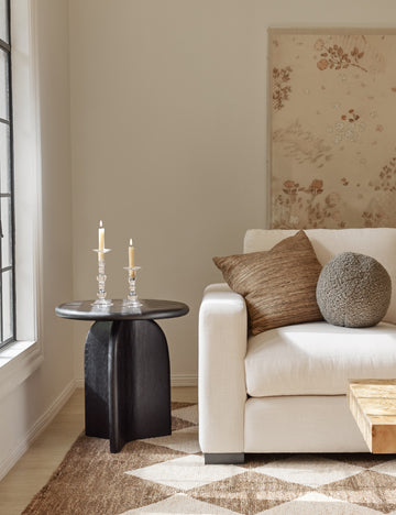 #showall::39723799281763 | Khaki gray Bouclé Ball Pillow by Sarah Sherman Samuel sits on an ivory couch next to a black side table and atop a patterned rug