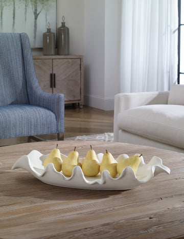#color::white | Beline low-profile ruffled long decorative bowl styled on a coffee table filled with pears.