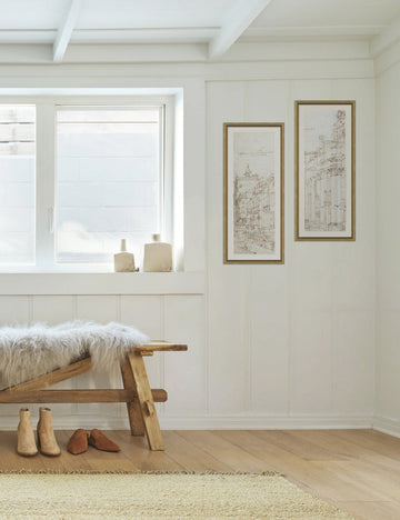 #size::22--x-25.5- | The set of two Da Vinci diptych drawing prints are hung against a white accented wall in an entry way with a wooden bench