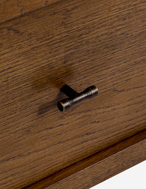 Close up of the drawer pull of the Ralston open shelf walnut nightstand