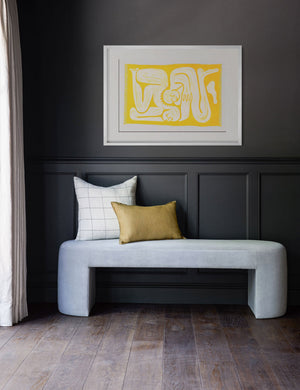 The Cloudgazers Print is hung horizontally in a white frame on a black wall above a light blue velvet bench
