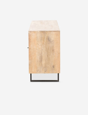 Side view of the Hannah natural mango wood sideboard with cane doors and an iron base.