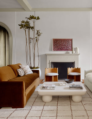 The Crane stencil 2 magenta and white wall art by ZBC house is hung above a fire place in a living room with sculptural furniture pieces