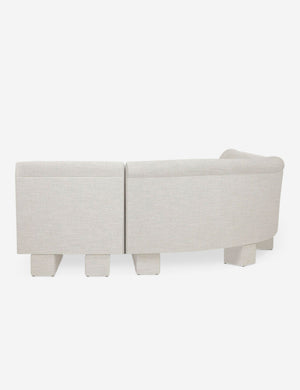 Rear view of the side of the Lena natural linen velvet sectional sofa with upholstered beam legs.