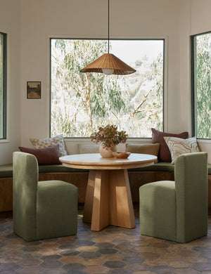 Terrene Woven Rattan Pendant by Elan Byrd hanging above a dining table.