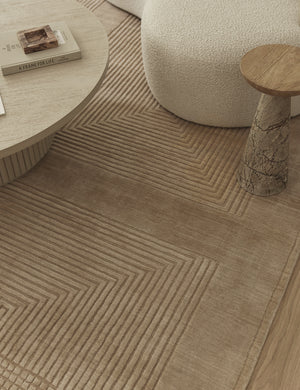 Halden handwoven carved design rug styled with a marble side table, boucle accent chair and round coffee table.