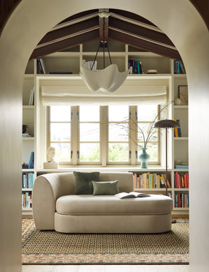 A chaise sitting a top the Manca traditional geometric motif hand-knotted wool rug.