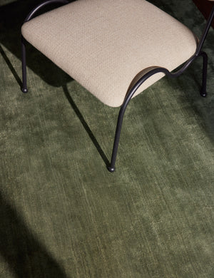 Close up view of the Sutton Solid Color Hand-Loomed Viscose Rug by Aimee Song under a dining chair