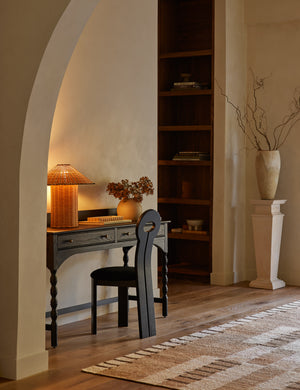 Terrene Woven Rattan Table Lamp by Elan Byrd styled on a desk.