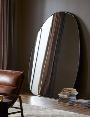 Platero modern oval leaning floor mirror against a wall