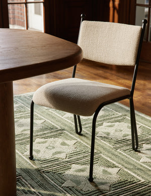Fidia curved metal silhouette dining chair by Aimee Song next to a dining table