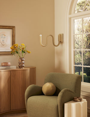 Noor sculptural, wavy swing arm wall sconce styled in a living room