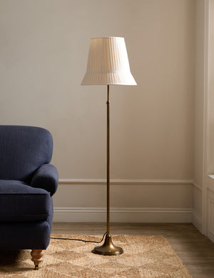 Lily slim metal stem adjustable height floor lamp by Heidi Caillier styled next to a sofa