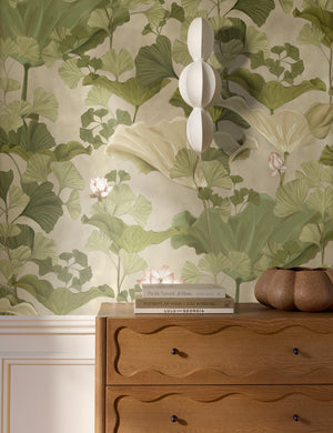 Lotus lush botanical wallpaper by Aimee Song on a wall behind a dresser