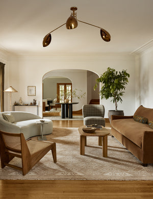 A living room featuring the Abanu mid-century adjustable brass chandelier.