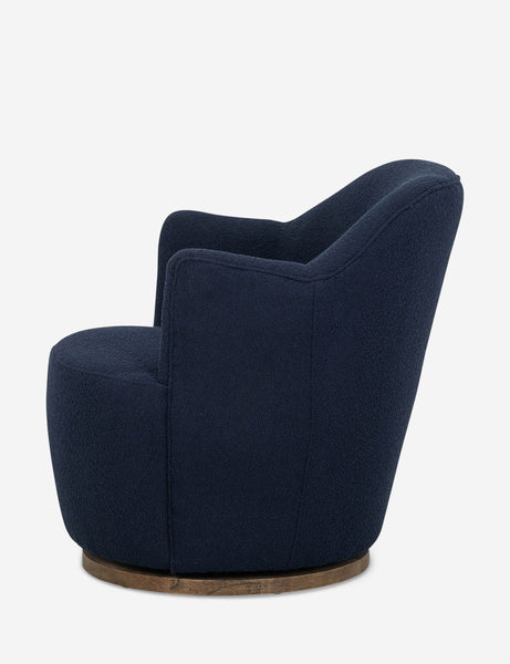 #color::navy | Side view of Margie rounded barrel swivel accent chair in navy