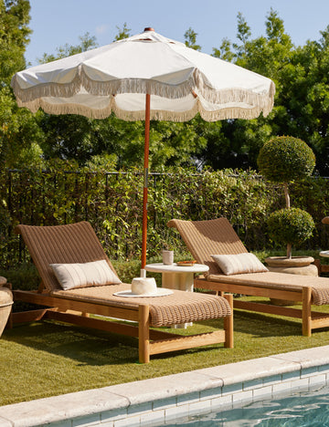 #color::natural | Two Gally wicker and teak outdoor chaise and umbrella by the poolside.