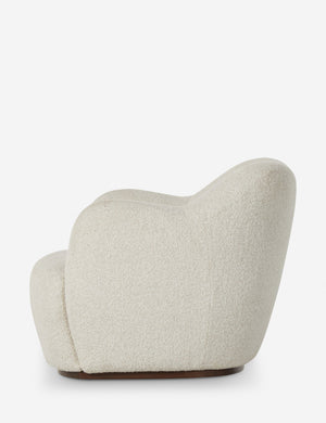 Side profile of the Selkie modern barrel swivel chair in ivory boucle.