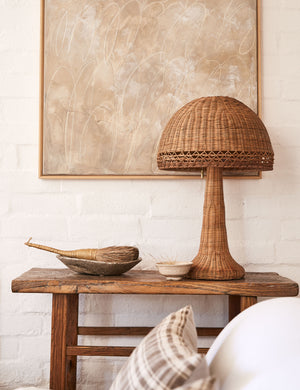 Quinley dome rattan coast table lamp styled on a rustic accent table.
