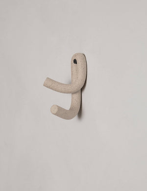 Cream speckled Leggy Crossed Wall Hook by SIN Ceramics hanging from a gray wall