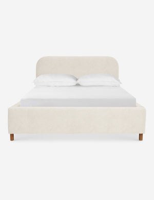 Solene Boucle Cream platform bed with an arched headboard and oak wood legs