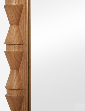 Close up of the frame details of the Topia arched carved wood frame floor mirror by Ginny Macdonald in natural.