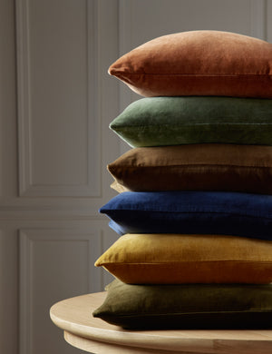 Charlotte velvet pillow in olive green, mustard, true blue, toast, moss, and burnt orange are stacked atop each other