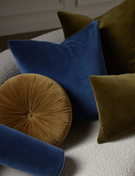 #color::true-blue #style::square  #fill type::with-feather-down-insert  #fill type::pillow-cover-only |   Charlotte velvet pillow in olive and true blue sit on a cream boucle lounger with other velvet pillows