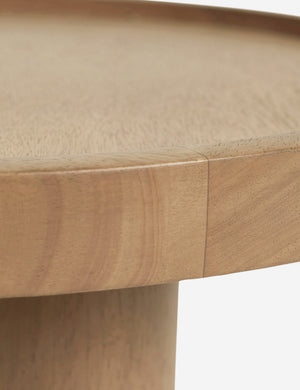 Close-up of the rim on the surface of the Delta natural wooden side table with pedestal base