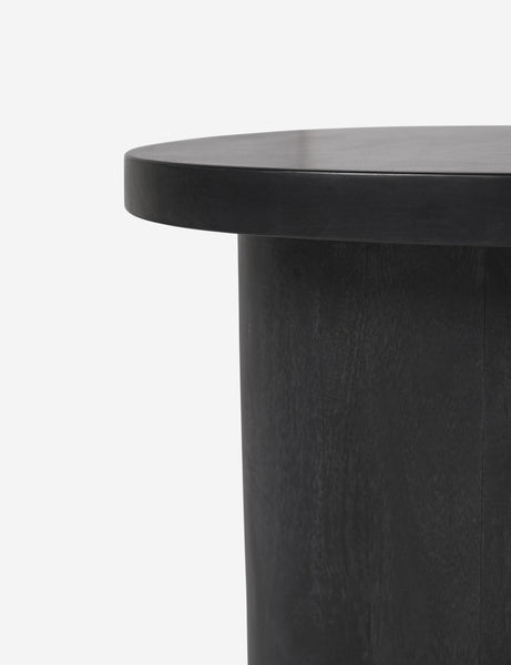 #color::black | Close-up of the rim of the top of the Luna black wood round side table and the leg