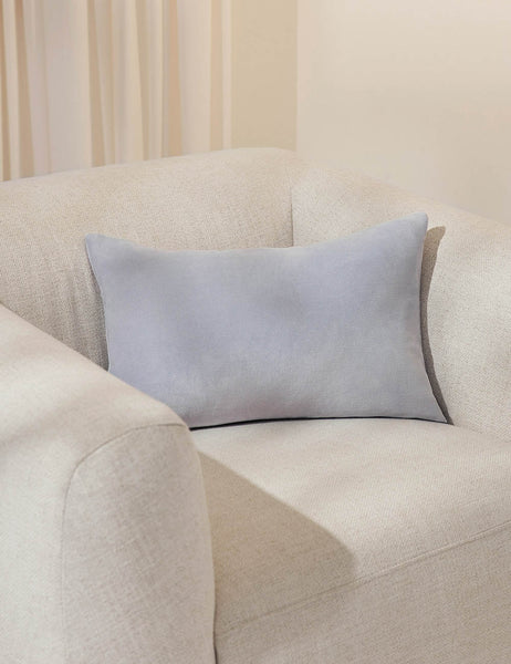 #color::ice-blue #size::13--x-20- #style::lumbar #fill type::with-feather-down-insert  #fill type::pillow-cover-only |   Charlotte ice blue lumbar velvet pillow sits on a white accent chair with a white curtain in the background