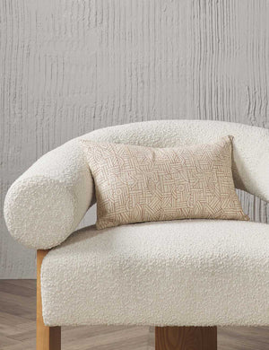 The Kisha natural-toned lumbar throw pillow sits on a cream boucle accent chair in a studio room