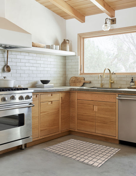 #size::1-9--x-2-10- #size::2--x-5- | The Sebou natural and black dotted machine washable mat lays in a kitchen with a subway tile backsplash and wooden cabinetry 