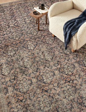 Billie Rug in ink and salmon by Amber Lewis x Loloi lays under a cream boucle accent chair and small wooden side table