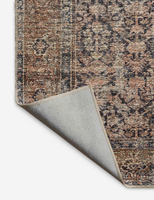Corner shot of the Billie Rug in ink and salmon by Amber Lewis x Loloi with the corner folded over