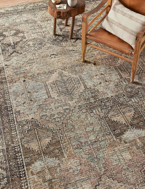 Billie Rug in clay and sage by Amber Lewis x Loloi lays under a brown leather wooden-framed accent chair