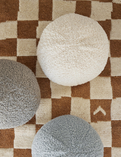 #color::ivory | Bird’s-eye view of the Ivory Bouclé Ball Pillow by Sarah Sherman Samuel on a ochre and white patterned rug