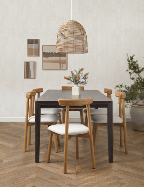 #color::natural | The Beehive jute woven pendant light is hung above a black rectangular dining table that is surrounded by six dining chairs