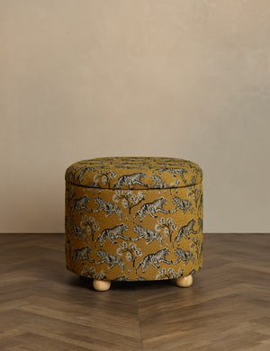  Kamila tiger golden round 24 inch ottoman with storage space and pinewood feet by Sarah Sherman Samuel sits in a studio room