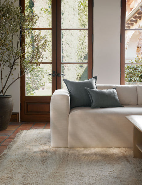 #color::dusty-blue #style::lumbar #fill type::with-feather-down-insert #fill type::pillow-cover-only | The arlo Dusty Blue flax linen pillow in its lumber and square sizes sit together on a natural linen sofa