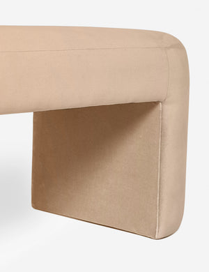 Close-up of the side and inner wall of the Mikhail light pink velvet foam-padded bench.