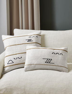 The Iconic ivory stripe square pillow and lumbar pillow sit together on a natural linen sofa