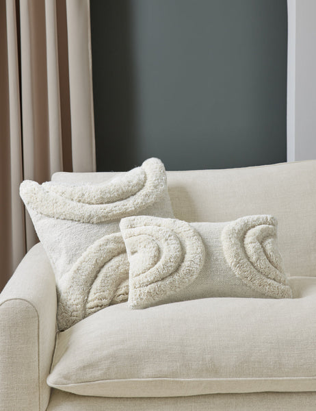 #color::natural #size::lumbar #size::square | The arches ivory pillow in both sizes are in a studio room sitting atop a natural linen sofa