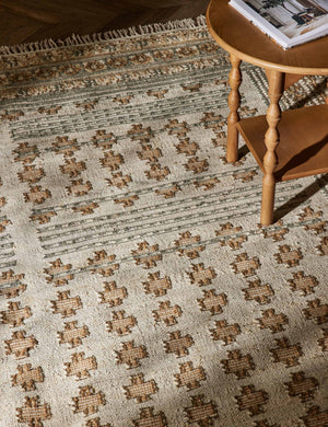 Close-up of the Keziah slate rug under a round side table with sculptural legs