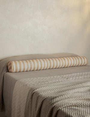 Painterly stripe linen long bolster throw pillow in natural and ivory styled on a bed