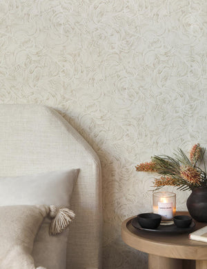 The parma wallpaper is in a bedroom with a natural linen framed bed and a wooden round nightstand