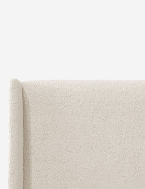 Close-up of the subtle winged headboard and trim lines on the Adara cream sherpa upholstered bed.
