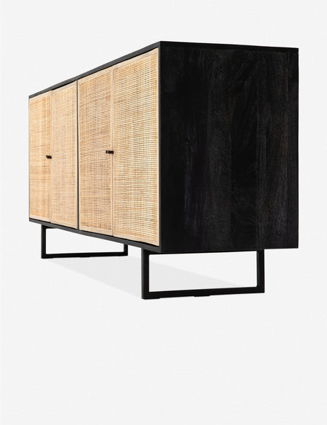 #color::black-and-natural | Angled side view of the Hannah black mango wood sideboard with cane doors and an iron base.