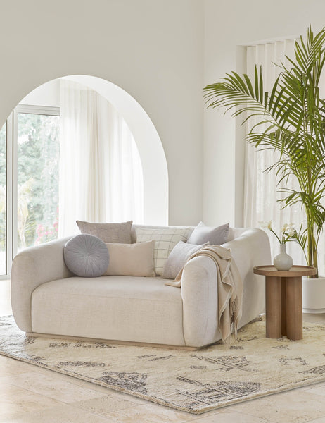 #color::ice-blue #style::square  #fill type::with-feather-down-insert  #fill type::pillow-cover-only |   Charlotte ice blue square velvet pillow sits on a linen lounger with other blue and neutral toned throw pillows